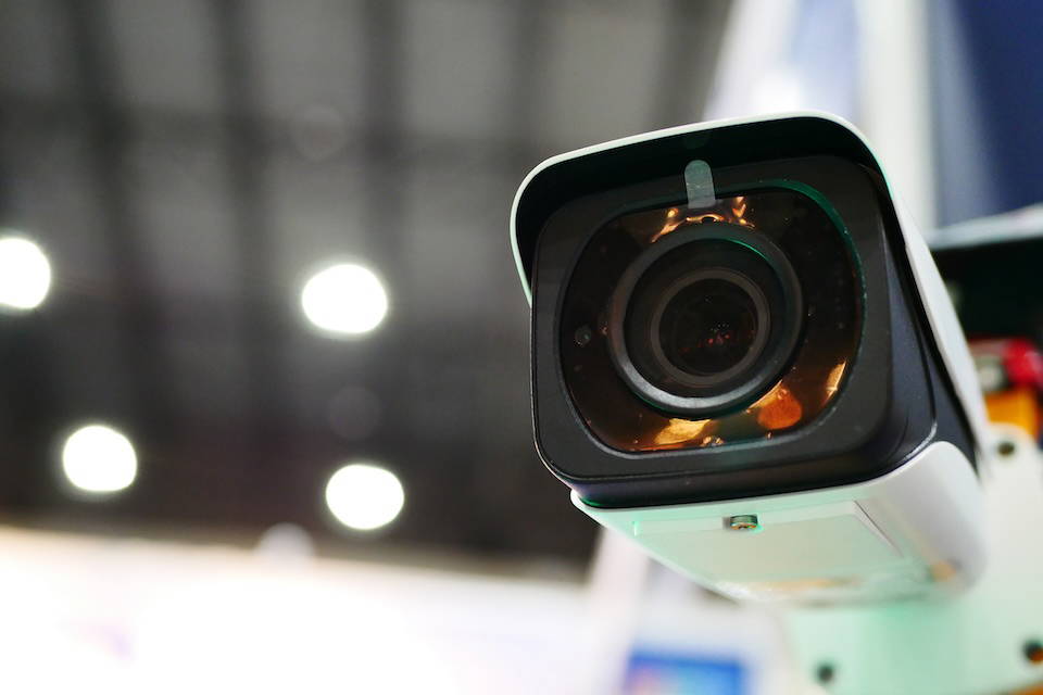 Close up image of a mounted CCTV surveillance camera in a commercial setting